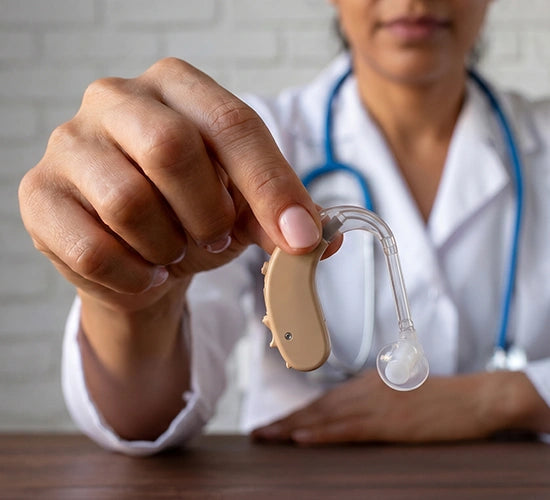 Physician holding a Tomore 5005 BTE hearing aid with a blurred background