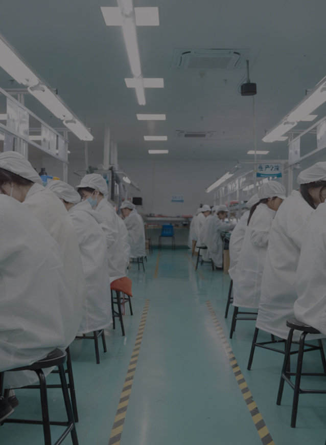 Factory workers in white coats and hats in a line, with a clean and organized layout.
