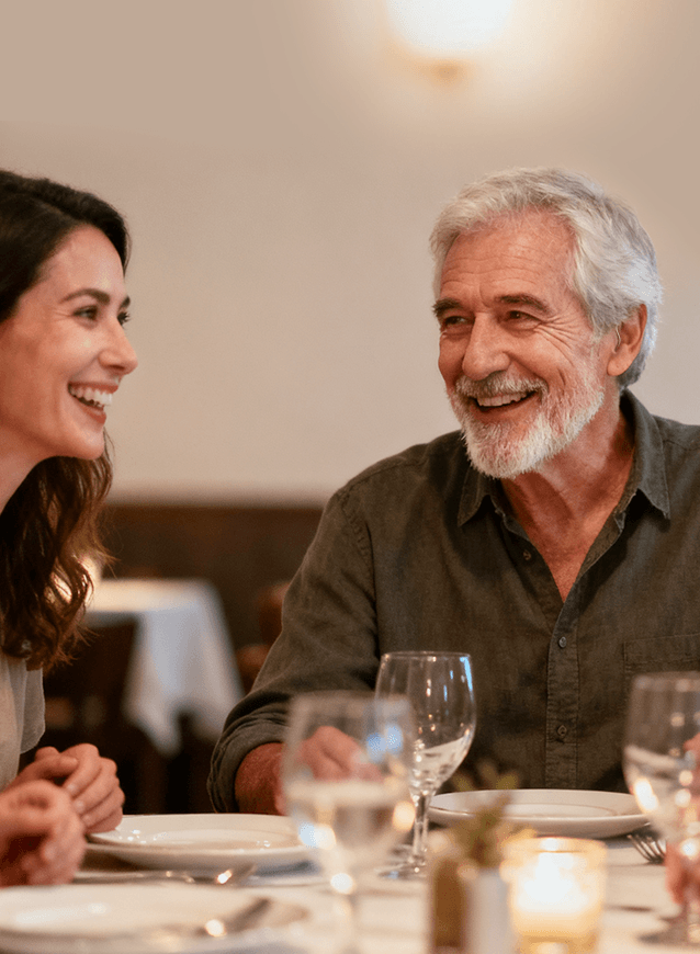 A Tomore hearing aid user enjoying a pleasant meal with friends in a restaurant.