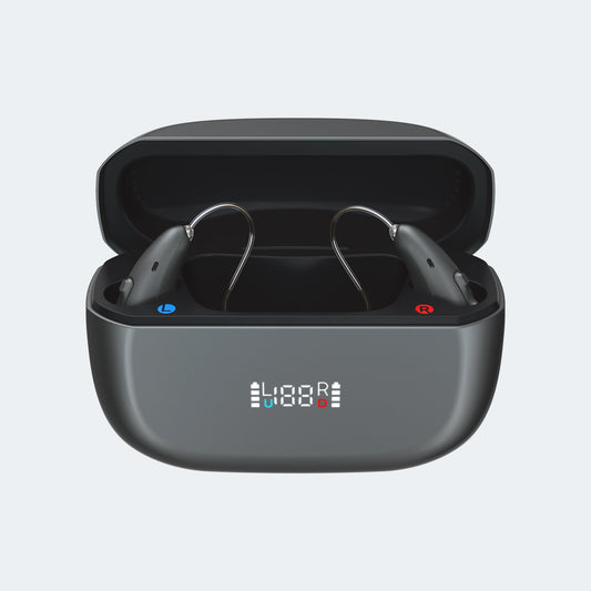 Black RIC hearing aids in an open charging case on a light gray background